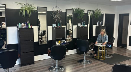 Modern salon interior at Salon Soiree, Denville, New Jersey, US, featuring stylish black chairs and wall mirrors.
