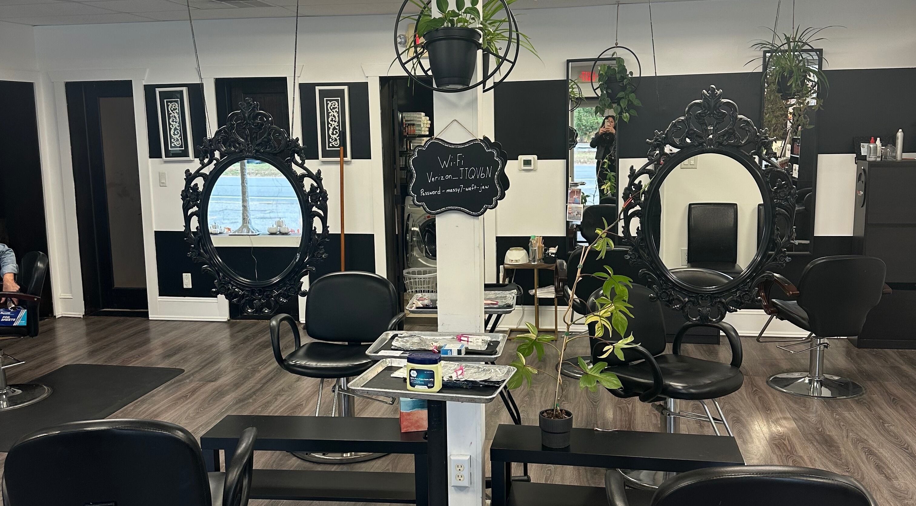 Spacious interior of Salon Soiree in Denville, New Jersey, US featuring ornate black mirrors and sleek chairs.