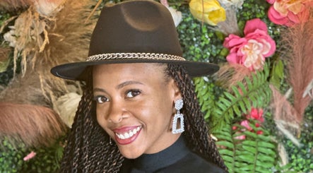 Woman smiling at Black Oasis Luxury Mind and Body, Lithonia, GA, Georgia, US with floral backdrop.