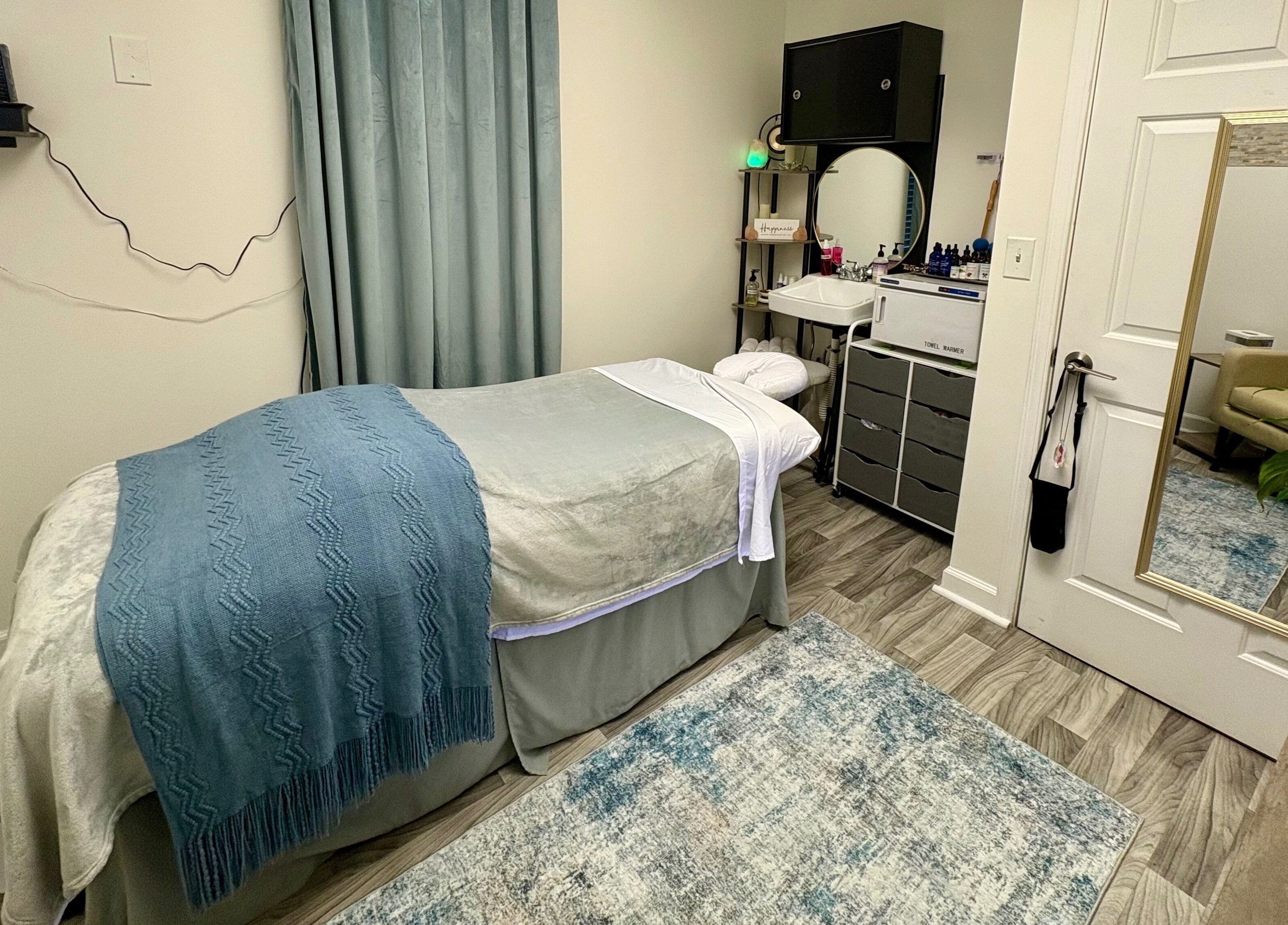 Relaxing spa room at Black Oasis Luxury Mind & Body in Conyers, Georgia, US with massage bed and elegant decor.