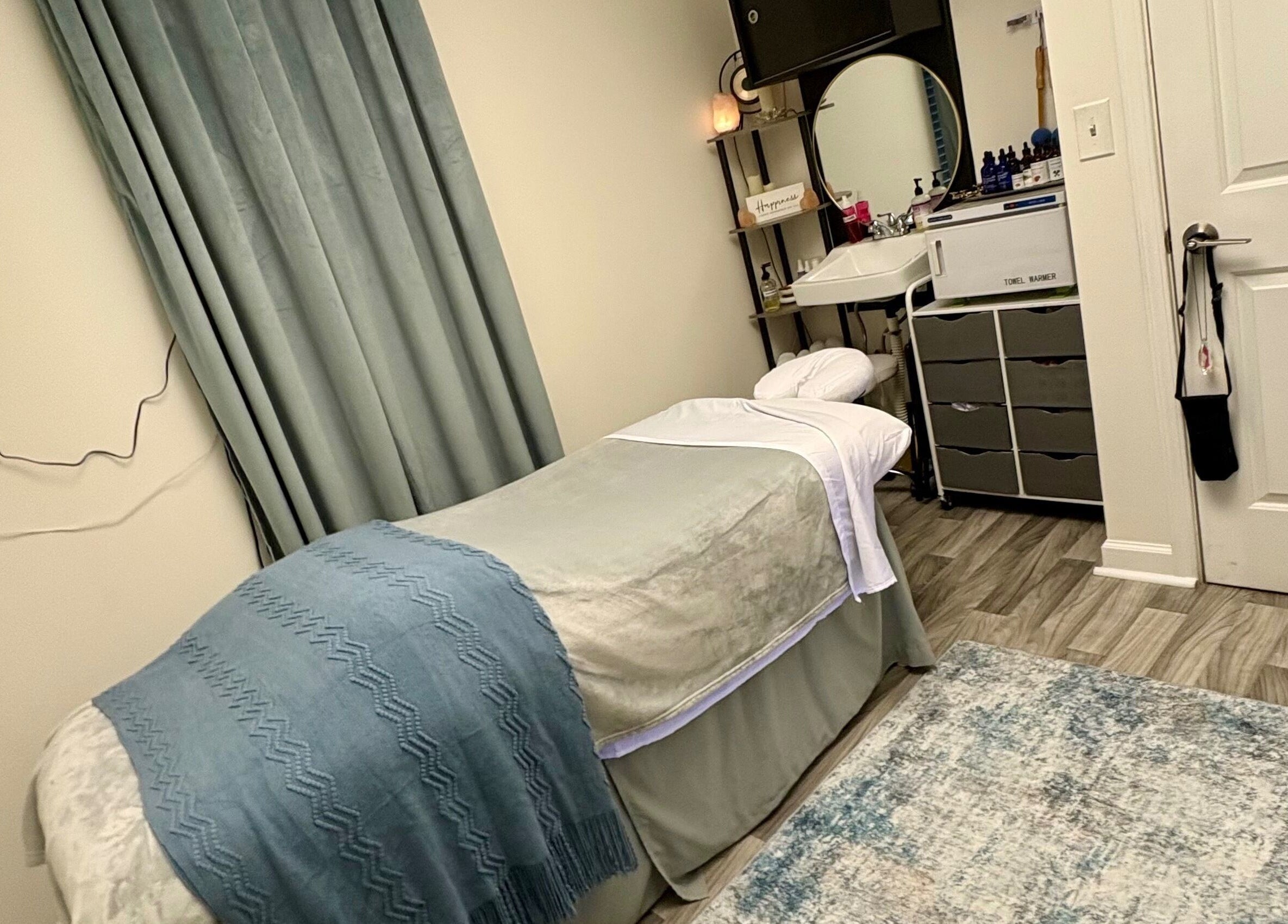 Serene spa room at Black Oasis Luxury Mind & Body in Conyers, Georgia, US, featuring a massage bed and elegant decor.