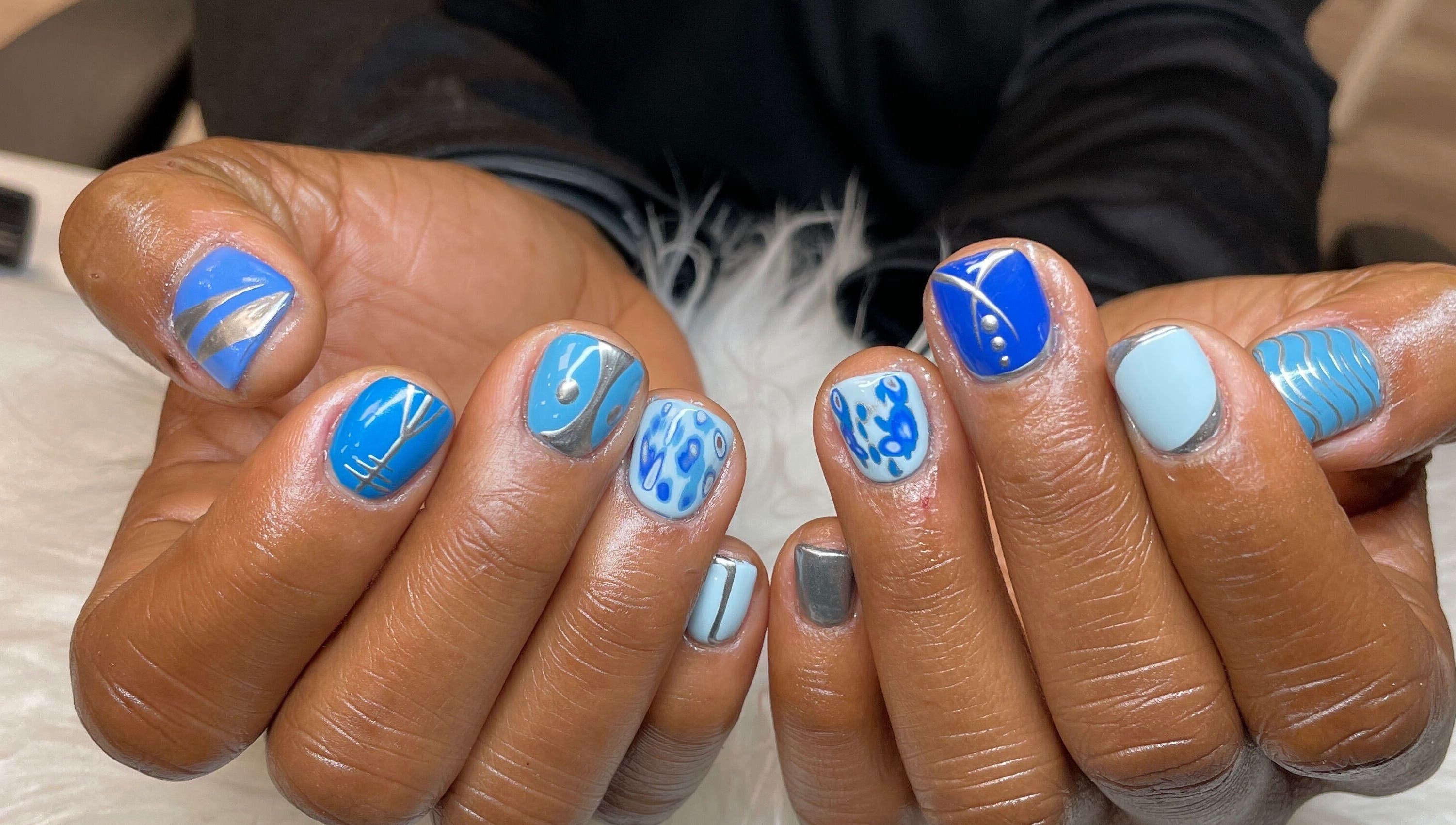 Creative blue nail art design at Nubian Nails, Morrow, Georgia, US.