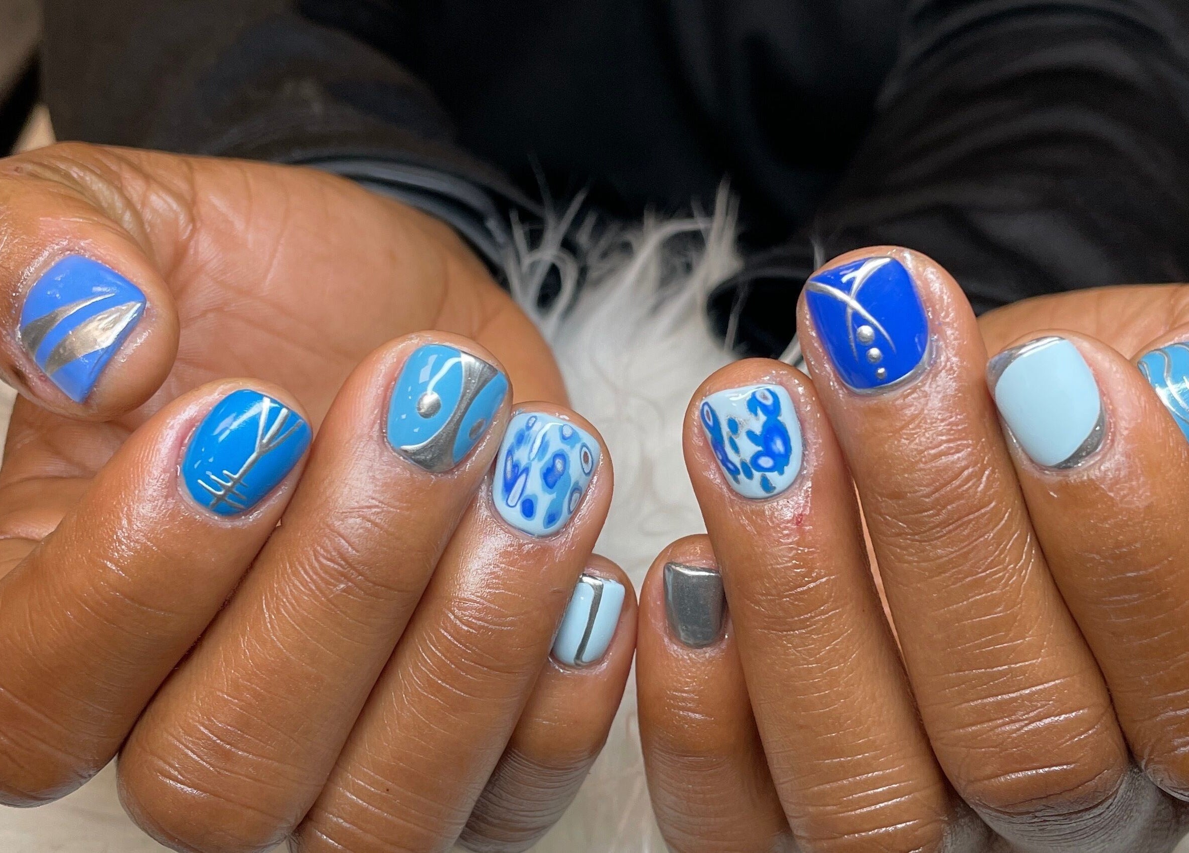 Creative blue nail art design at Nubian Nails, Morrow, Georgia, US.