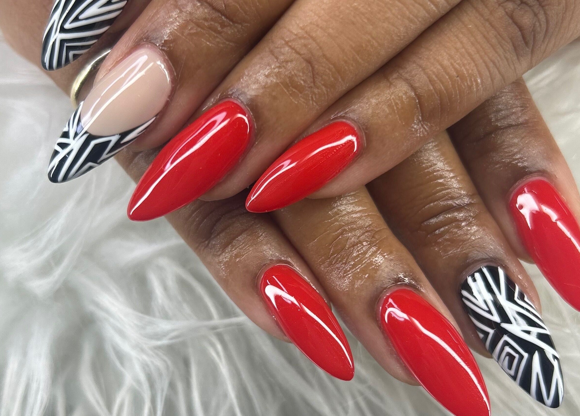 Stylish red and black nail art at Nubian Nails, Morrow, Georgia, US, showcasing elegant manicure design.