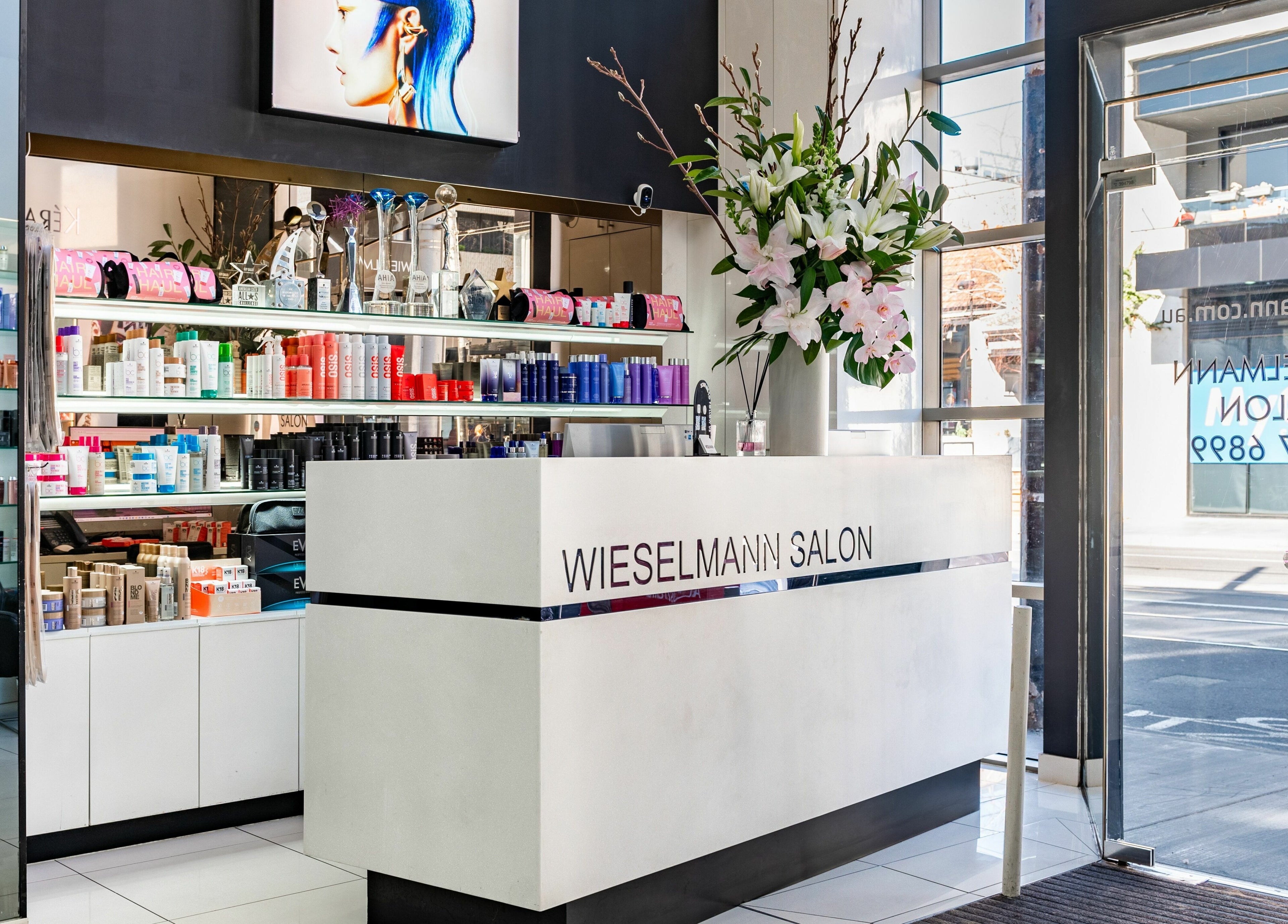 Elegant reception at Wieselmann Salon in South Yarra, VIC, AU, featuring stylish hair products and flowers.