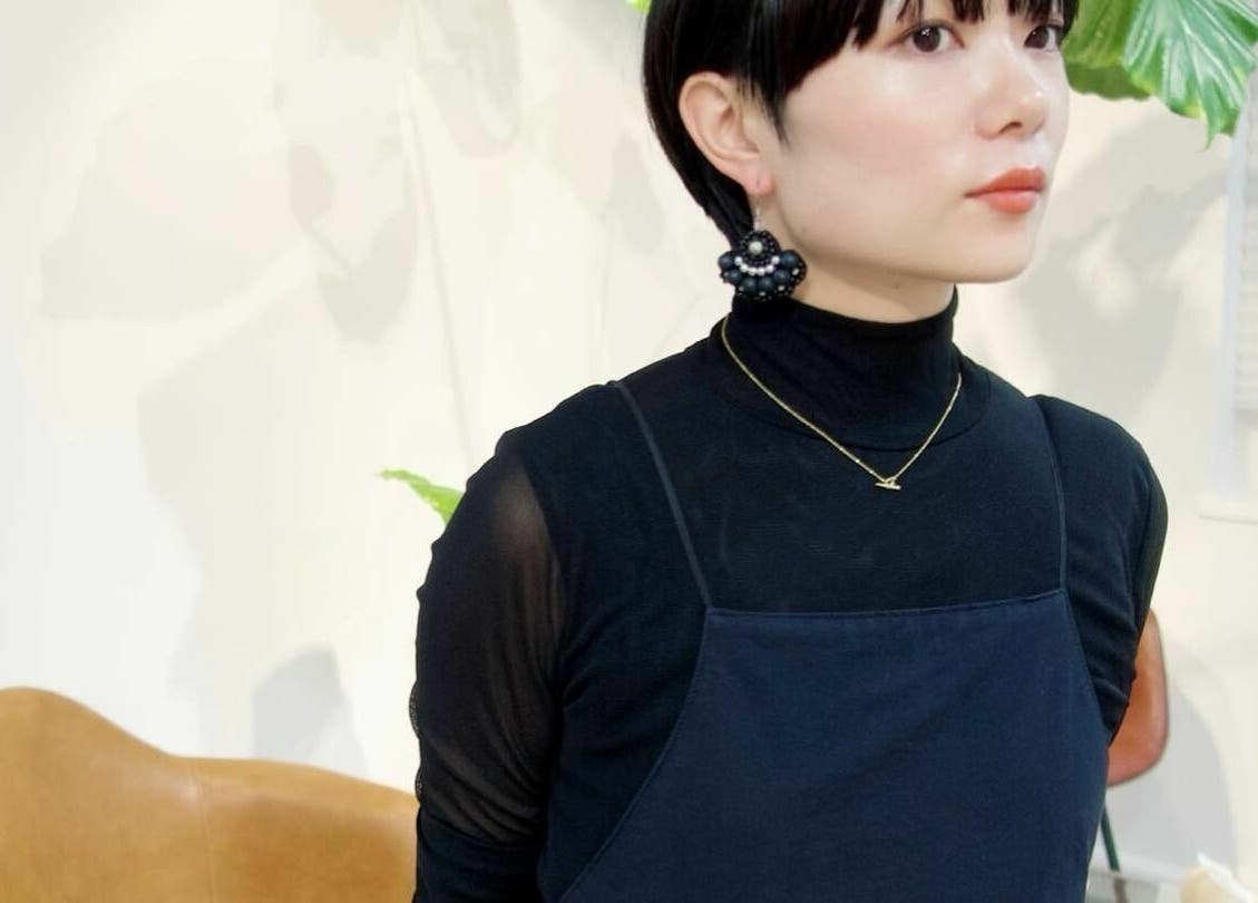 Stylish model at Fjino, Hong Kong Island, HK. Chic earrings and black attire in a modern setting.