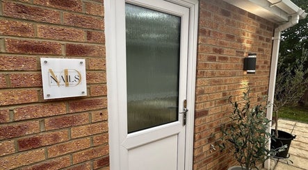 Entrance of MD Nails in Bishop's Stortford, England with elegant brickwork and signage.
