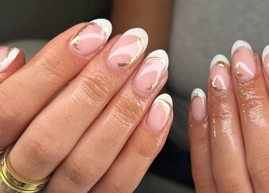 Elegant nail art at MD Nails, Bishop's Stortford, England. White and gold accents enhance the manicure.