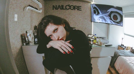 Interior del Nailcore® Studio en Lima, Provincia De Lima, PE, con una clienta mostrando uñas rojas.