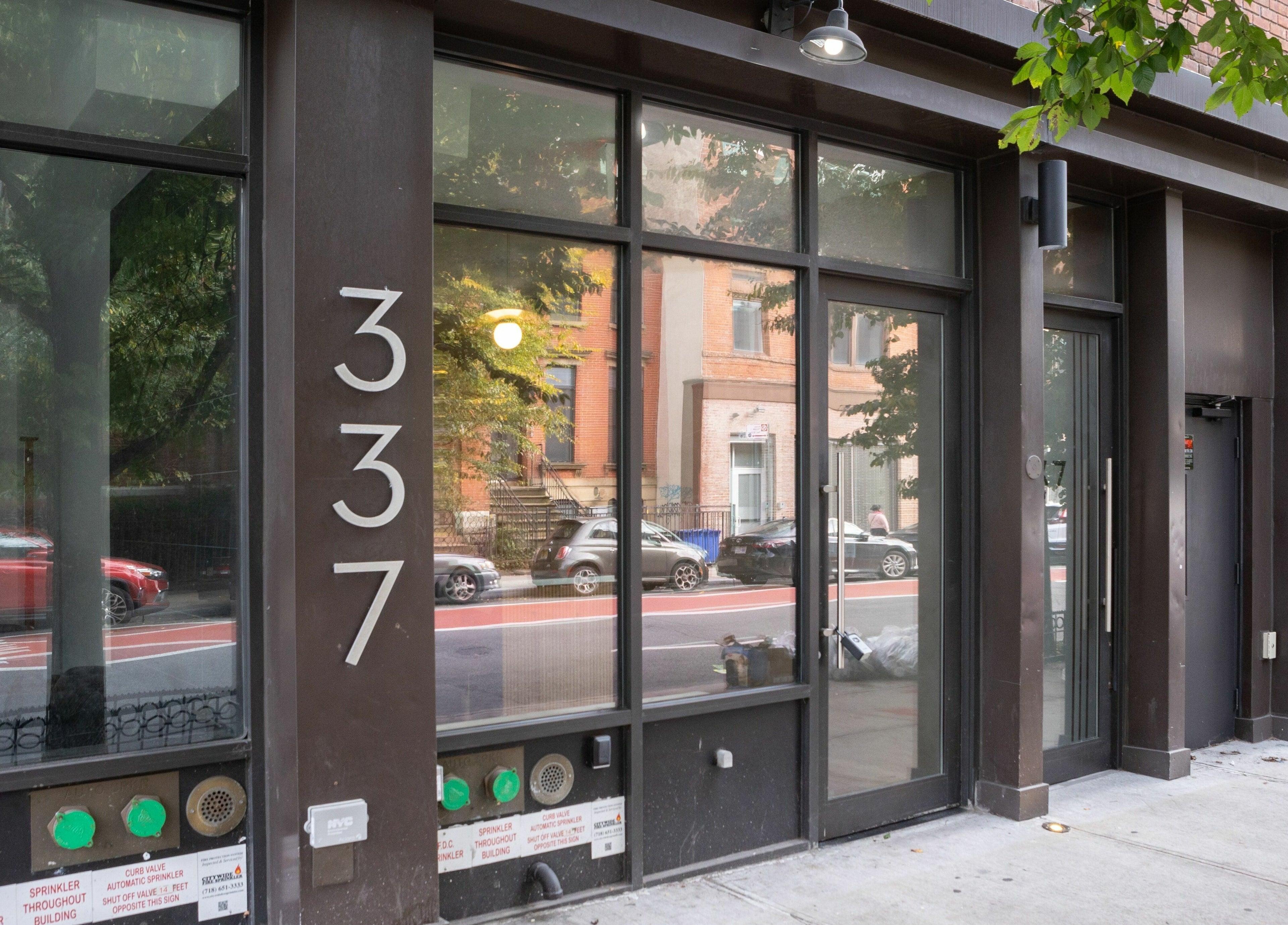 Front view of TASH BLAQUE at 337, New York, New York, US, showcasing modern glass and brick facade.