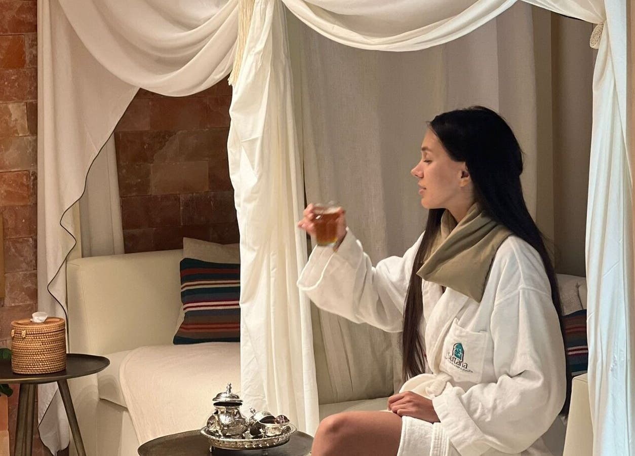 Woman enjoying tea in a cozy spa setting at Sultana Spa LLC, Dubai, AE.