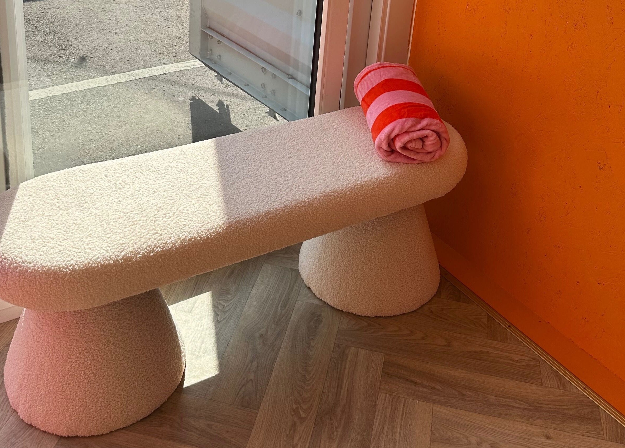 Comfortable bench with a striped towel at So Gel Studio, Bristol, England, GB enhancing a warm ambiance.