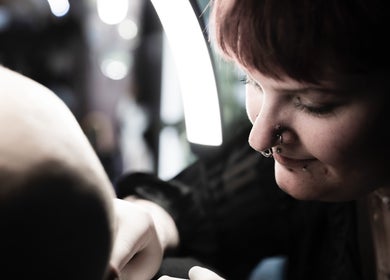 Professional piercer at work at Pin Cushion Piercing, Buckland, Waikato, NZ, showcasing precision and skill.
