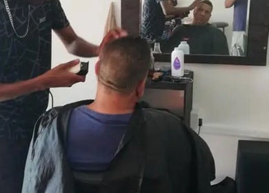 Barber at The Village Barbershop in Cape Town, Western Cape, ZA performing a stylish haircut.