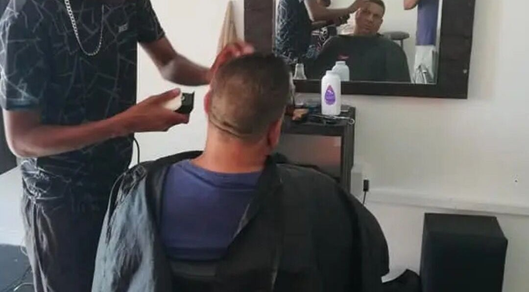 Barber at The Village Barbershop in Cape Town, Western Cape, ZA performing a stylish haircut.