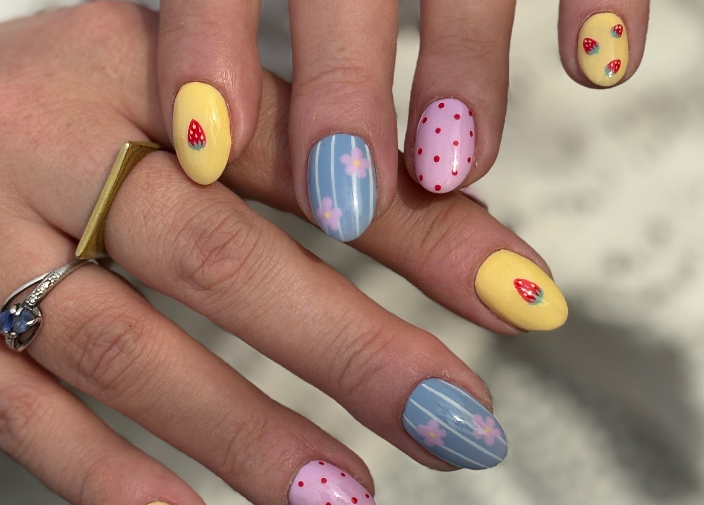 Colorful nail art at The Glossy Palette, Cape Town, Western Cape, ZA, showcasing strawberries and floral designs.