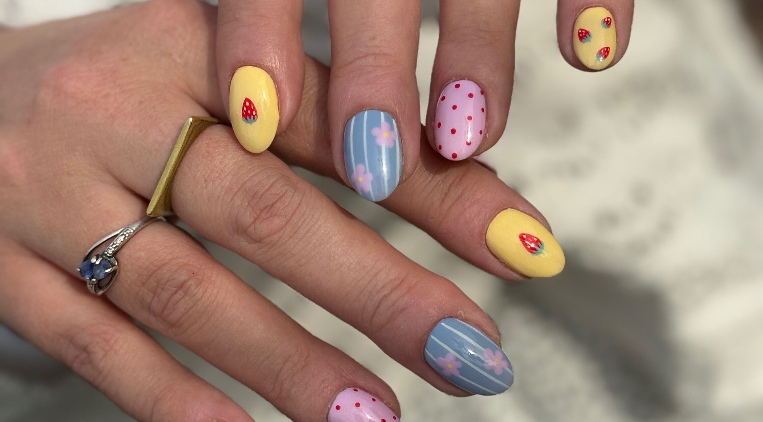 Colorful nail art at The Glossy Palette, Cape Town, Western Cape, ZA, showcasing strawberries and floral designs.