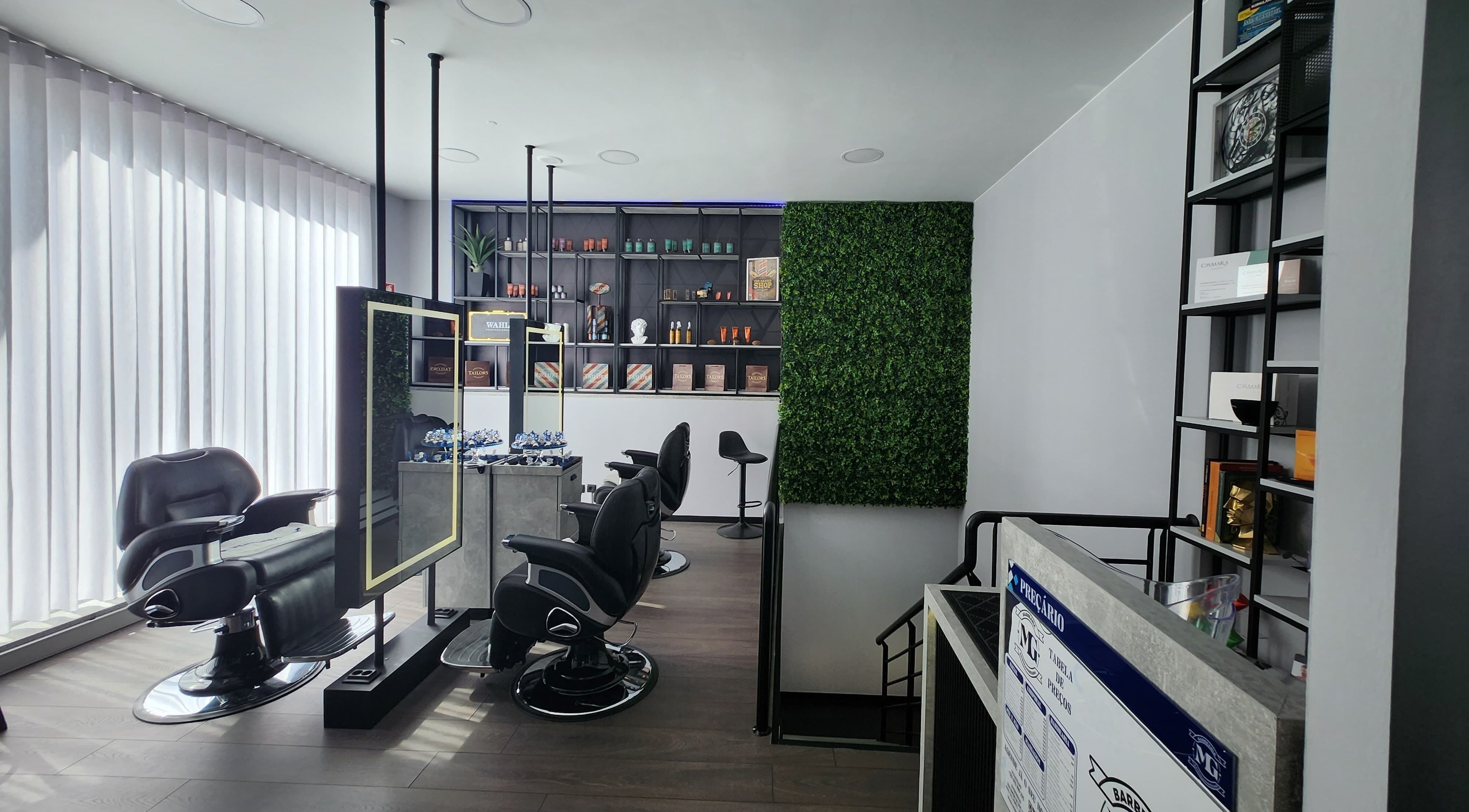 Interior moderno da MG Barbearia & Estética Masculina em Porto, Porto, PT com cadeiras de barbeiro elegantes.