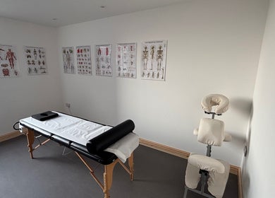 Therapy room at What Knot Sports Massage Therapy, Preston, England, GB, featuring a massage table and anatomy charts.