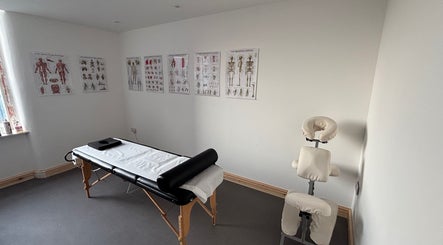 Therapy room at What Knot Sports Massage Therapy, Preston, England, GB, featuring a massage table and anatomy charts.