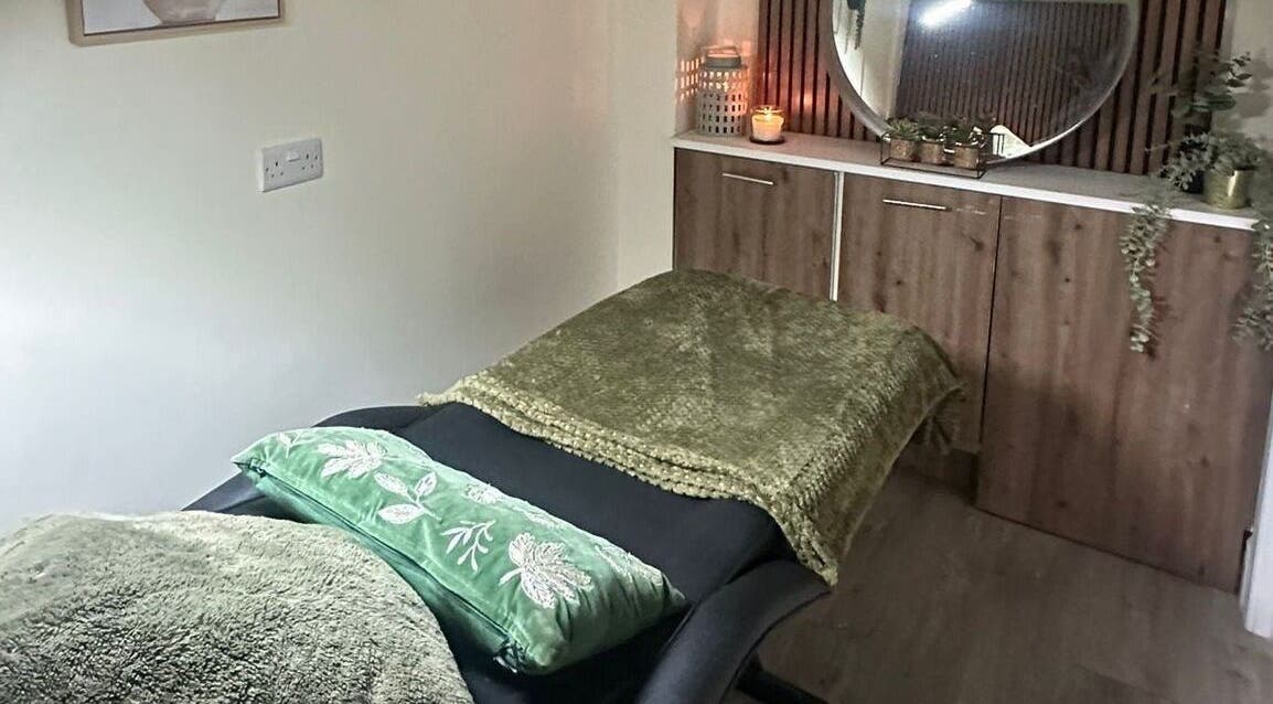 A serene massage room at Sage Beauty By Charelle, Kilmacolm, Scotland, GB with a cozy green blanket and candles.