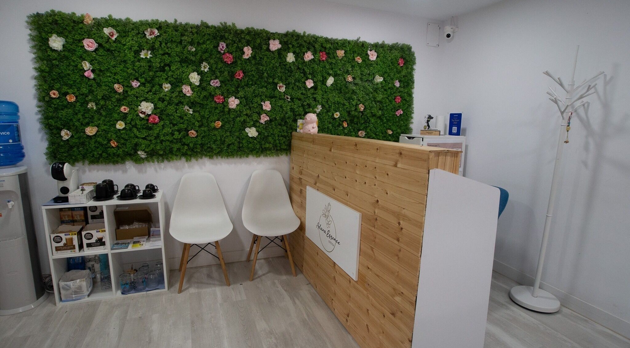 Recepción de Adara Essence Estetica en Sant Andreu Salou, Catalunya, con pared verde y flores decorativas.