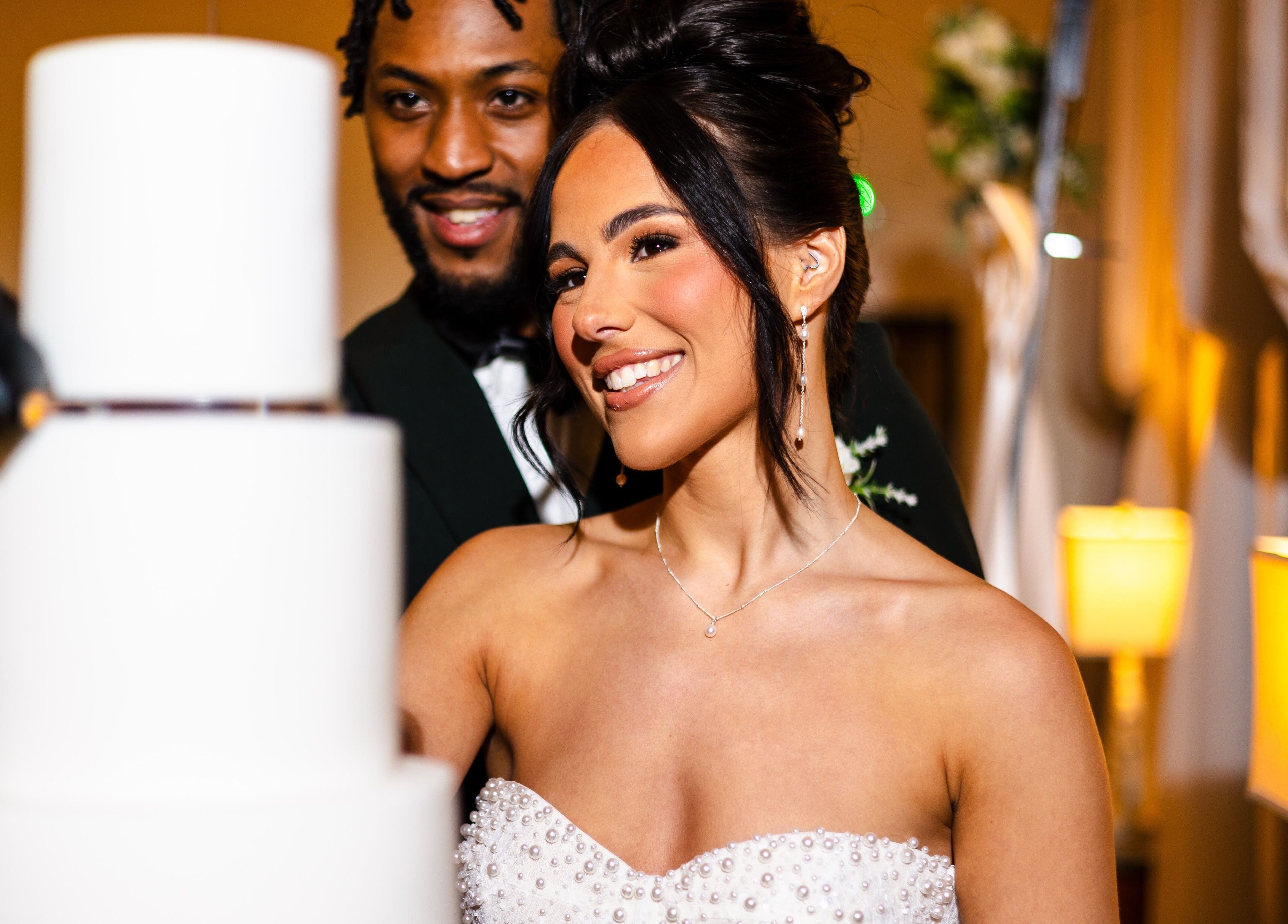 Bridal couple smiling with wedding cake, makeup by Elisha Simon, Northampton, England, GB.