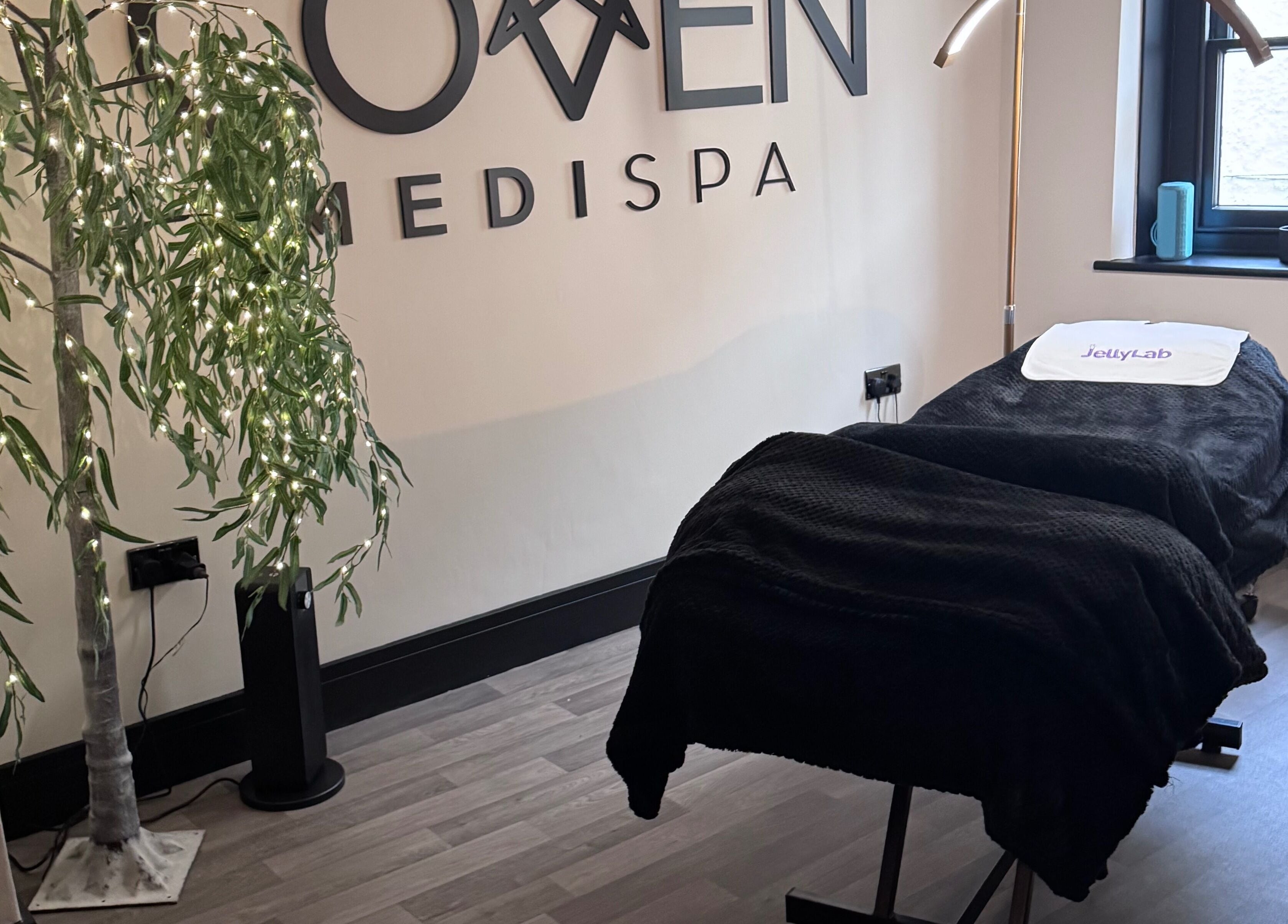 Relaxing treatment room at The Coven-Medi Spa in Bridgend, Wales, GB, featuring a cozy massage bed and soft lighting.