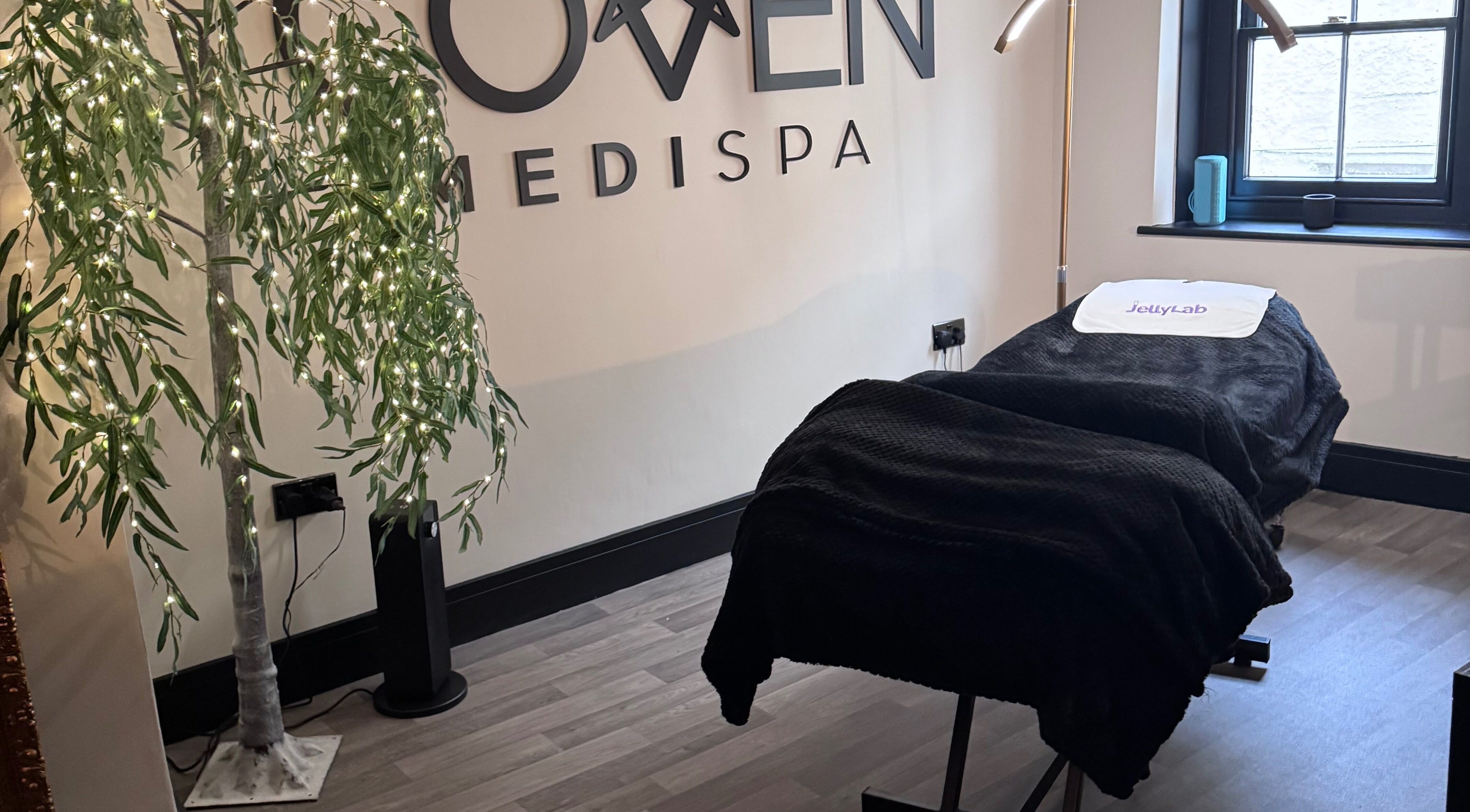 Relaxing treatment room at The Coven-Medi Spa in Bridgend, Wales, GB, featuring a cozy massage bed and soft lighting.