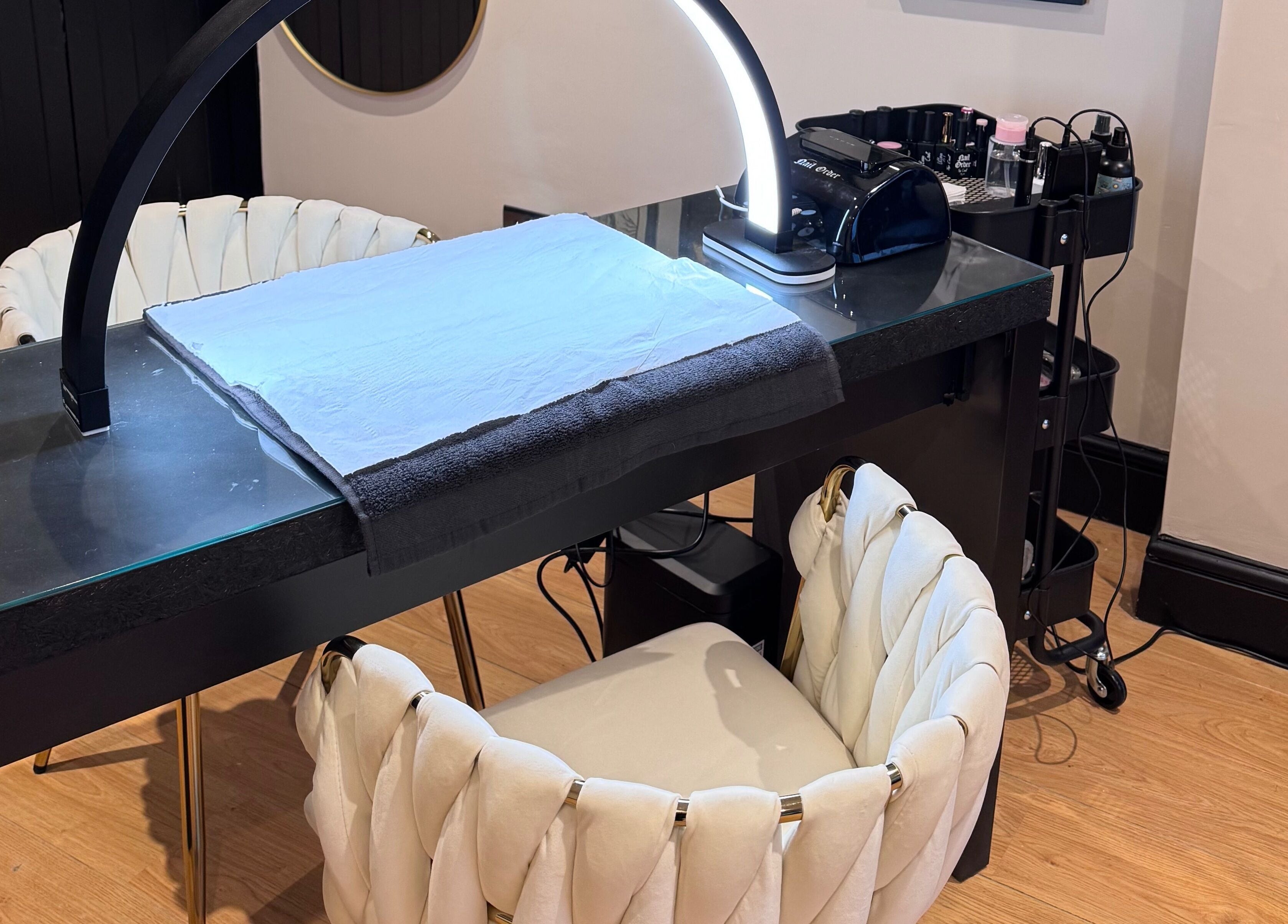 Nail station setup at The Coven- Medi Spa in Bridgend, Wales, GB featuring stylish chairs and modern equipment.