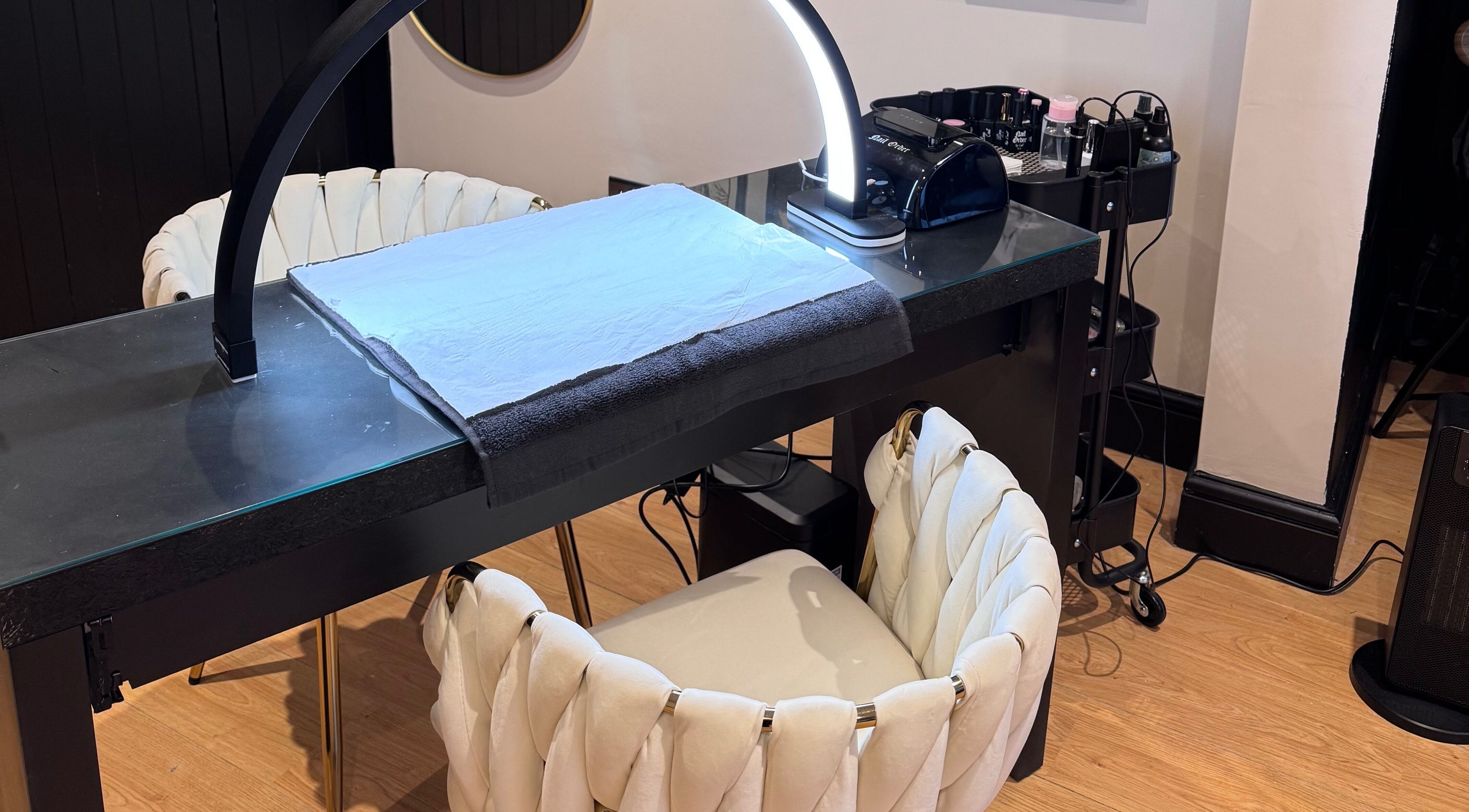 Nail station setup at The Coven- Medi Spa in Bridgend, Wales, GB featuring stylish chairs and modern equipment.