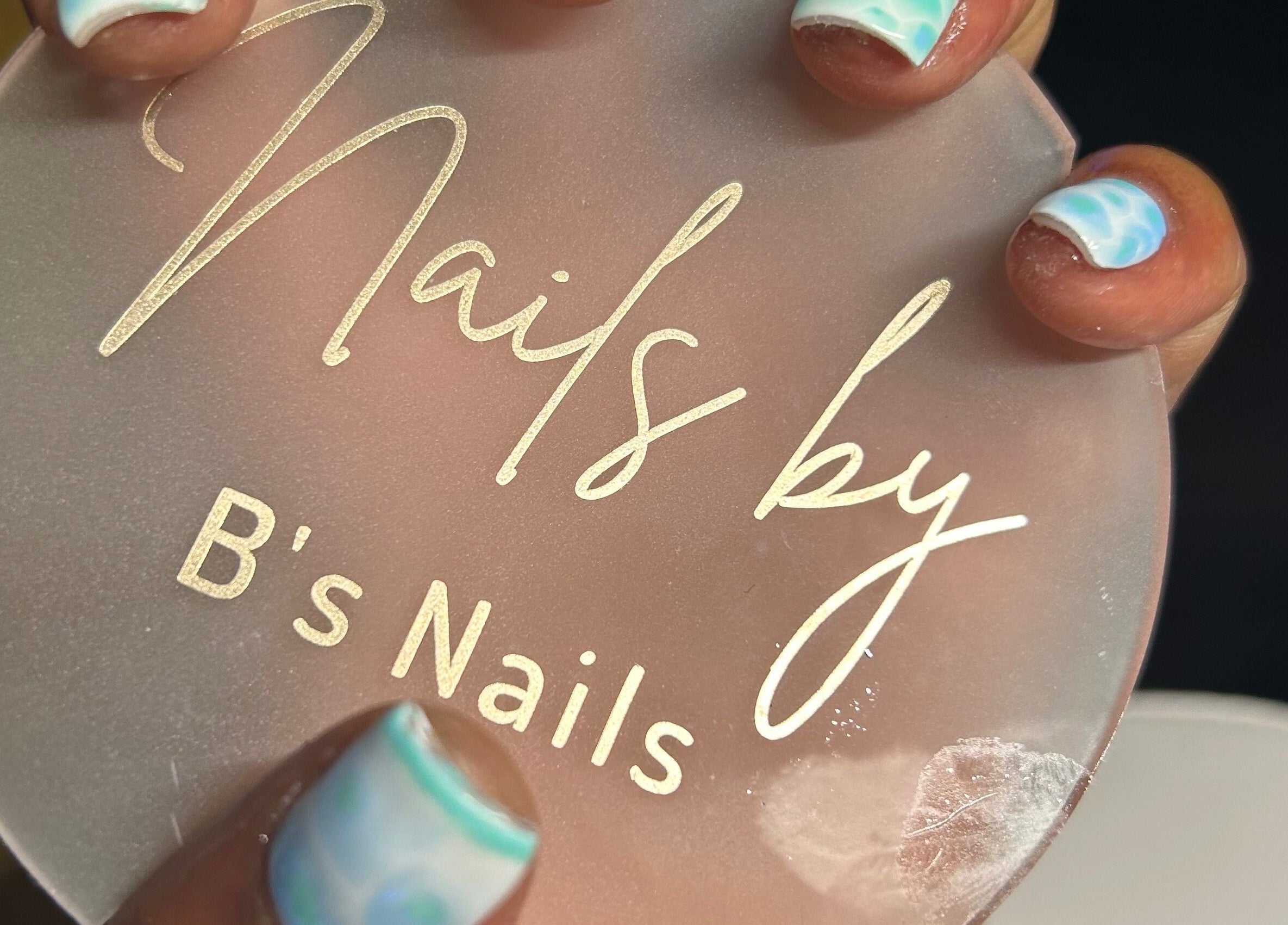 Beautifully manicured nails with B's Nails logo at Gosport, England, GB. Perfect nail art for stylish hands.