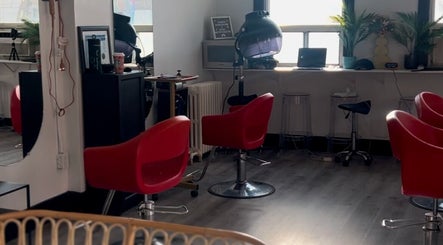 Interior of Curls by Jenn in Toronto, Ontario, CA featuring stylish red salon chairs and modern decor.