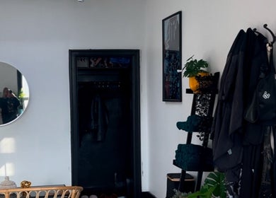 Stylish interior at Curls by Jenn in Toronto, Ontario, CA, featuring a round mirror and modern decor.