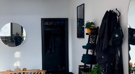 Stylish interior at Curls by Jenn in Toronto, Ontario, CA, featuring a round mirror and modern decor.