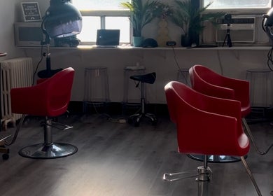 Modern salon interior with red chairs at Curls by Jenn, Toronto, Ontario, CA. Bright and inviting setting.