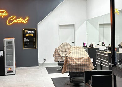 Interior of FadeCentral Barbershop, Enfield, NSW featuring two covered barber chairs and illuminated sign.