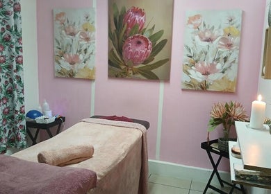 Cozy massage room with floral decor at Burgundy Blush Beauty Lounge, George, Western Cape, ZA.
