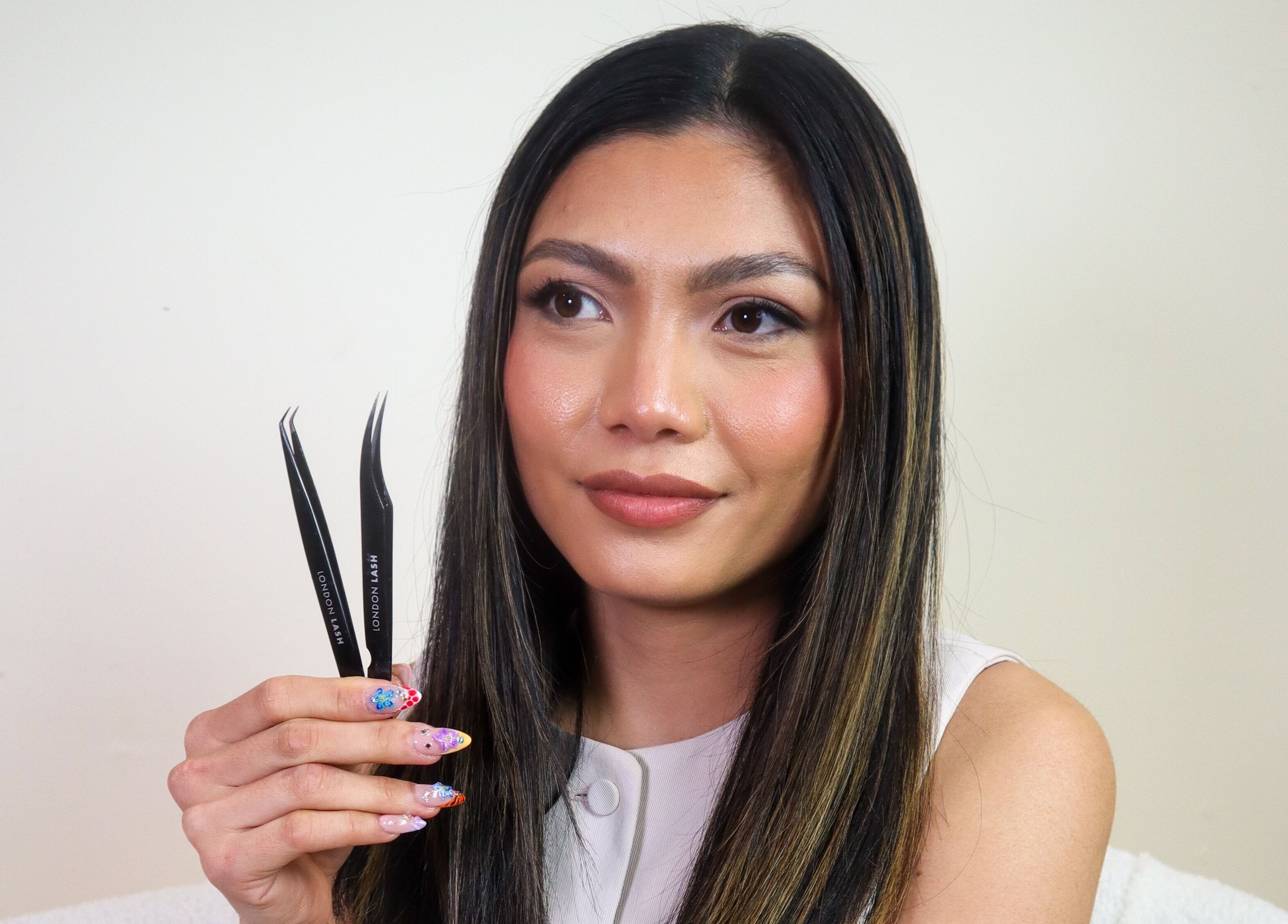 Woman showcasing lash tweezers at Glam Lashes Australia, Melbourne, Victoria, AU.
