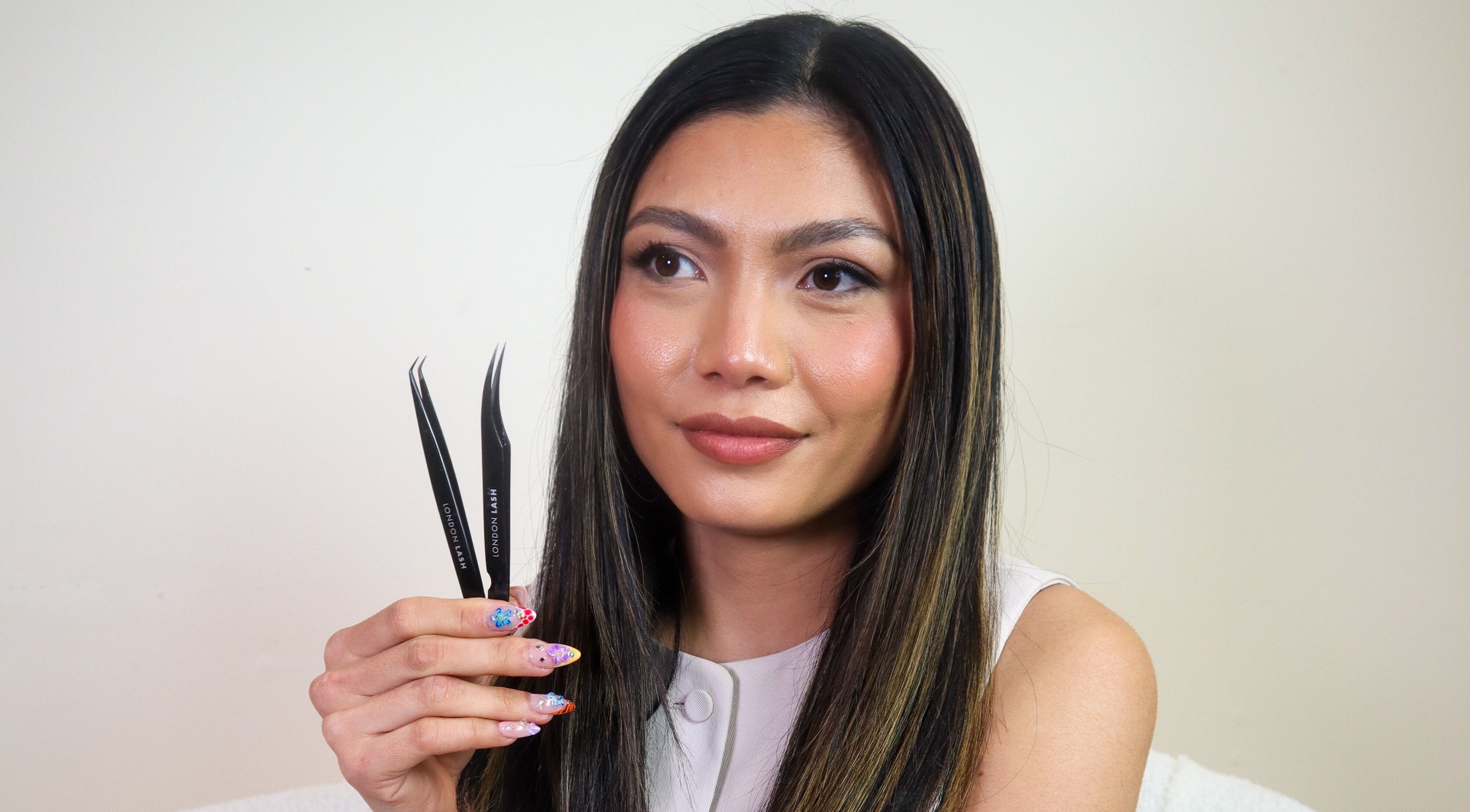 Woman showcasing lash tweezers at Glam Lashes Australia, Melbourne, Victoria, AU.