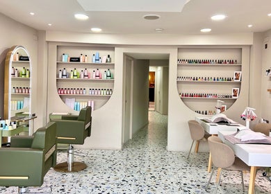Interior of Mami Yaba Salon in London, England, GB featuring stylish chairs and nail polish display.