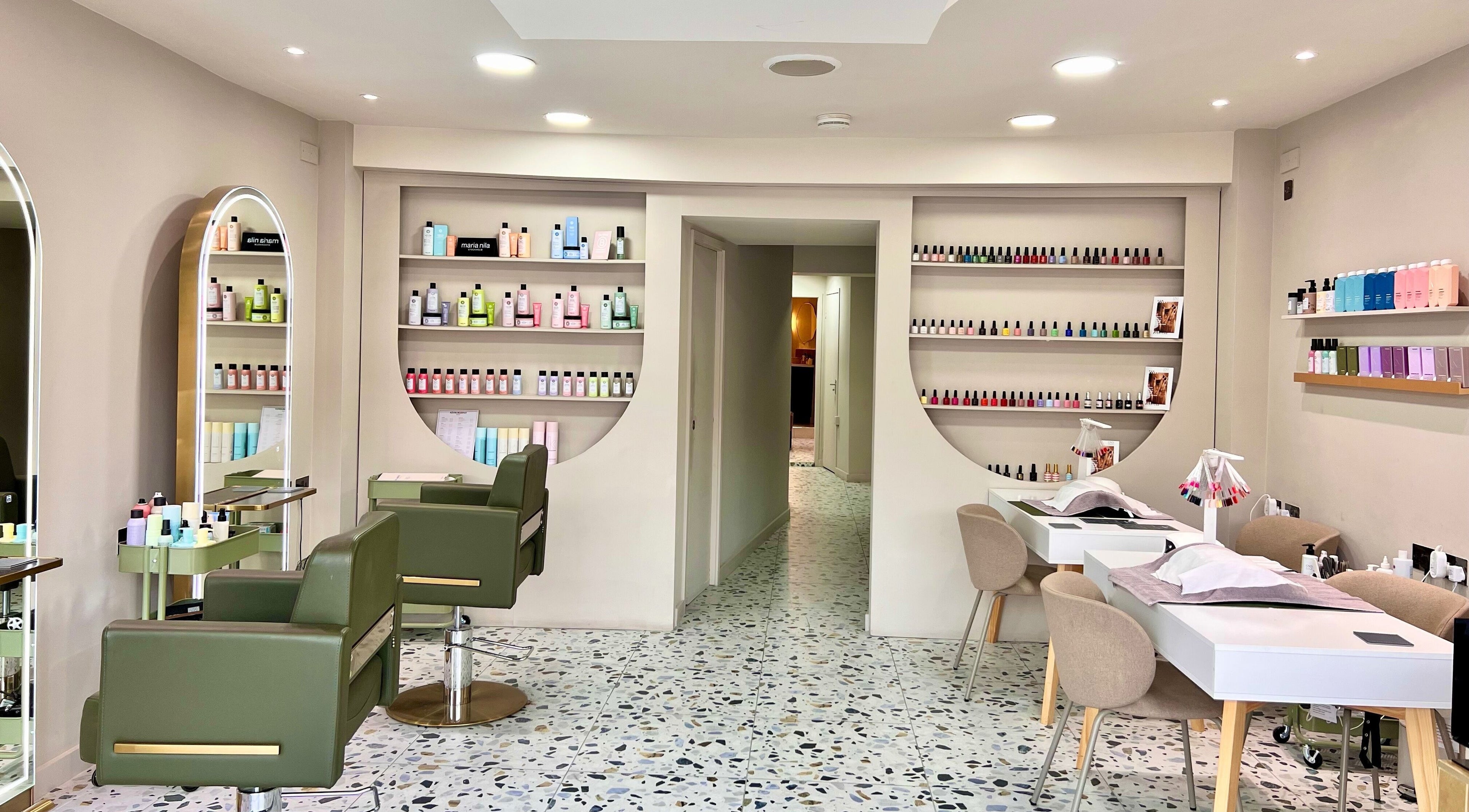 Interior of Mami Yaba Salon in London, England, GB featuring stylish chairs and nail polish display.