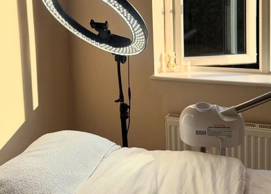 Serene treatment room at The Derma Clinic Cheshire, Hyde, England, with a massage table and professional lighting.