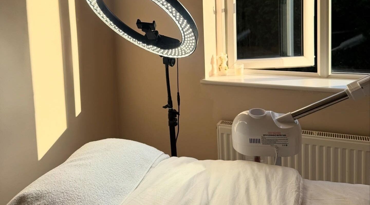 Serene treatment room at The Derma Clinic Cheshire, Hyde, England, with a massage table and professional lighting.