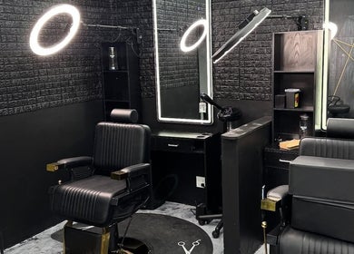 Modern barbershop interior at Milez Cutz, Nassau, New Providence, BS, featuring sleek black decor and styling chairs.