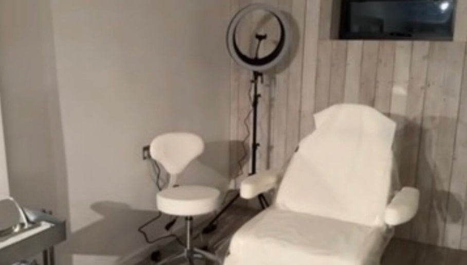 Modern treatment room at Baileys Clinic Ltd in Ferndown, England, with chair and equipment.