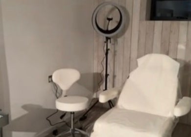 Modern treatment room at Baileys Clinic Ltd in Ferndown, England, with chair and equipment.