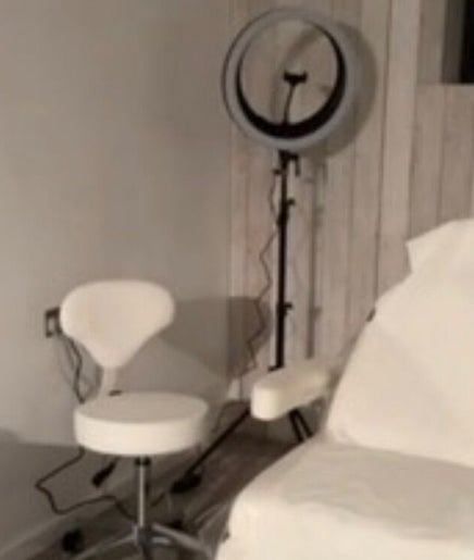 Modern treatment room at Baileys Clinic Ltd in Ferndown, England, with chair and equipment.