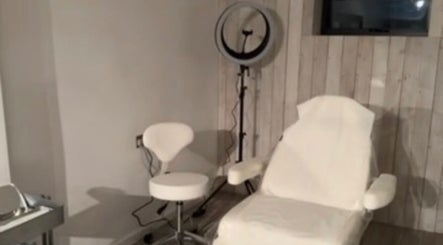 Modern treatment room at Baileys Clinic Ltd in Ferndown, England, with chair and equipment.