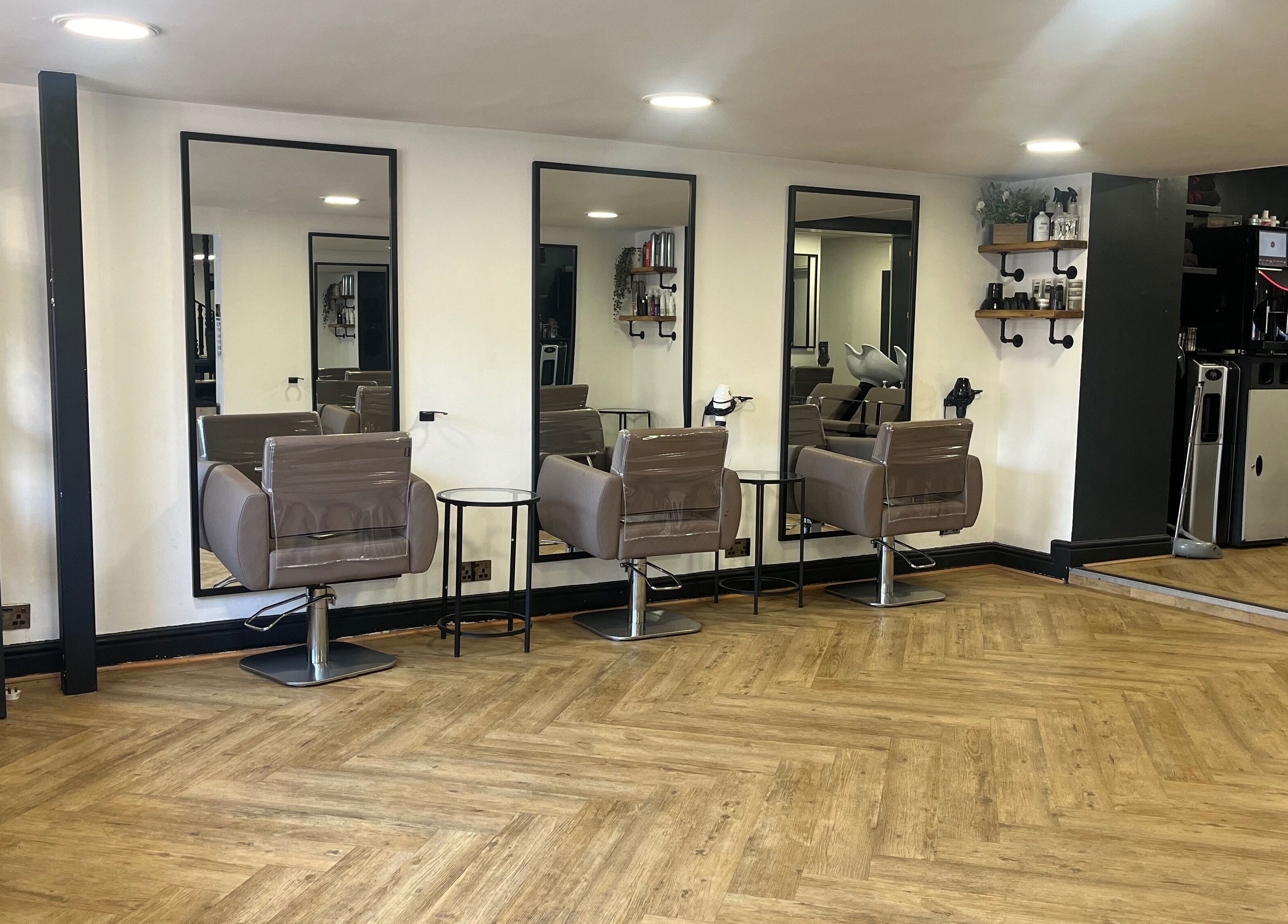 Modern salon chairs and mirrors at House of Finesse, Altrincham, England, GB, showcasing sleek design.